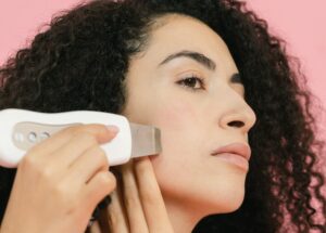 kobieta wykonuje peeling kawitacyjny w domu