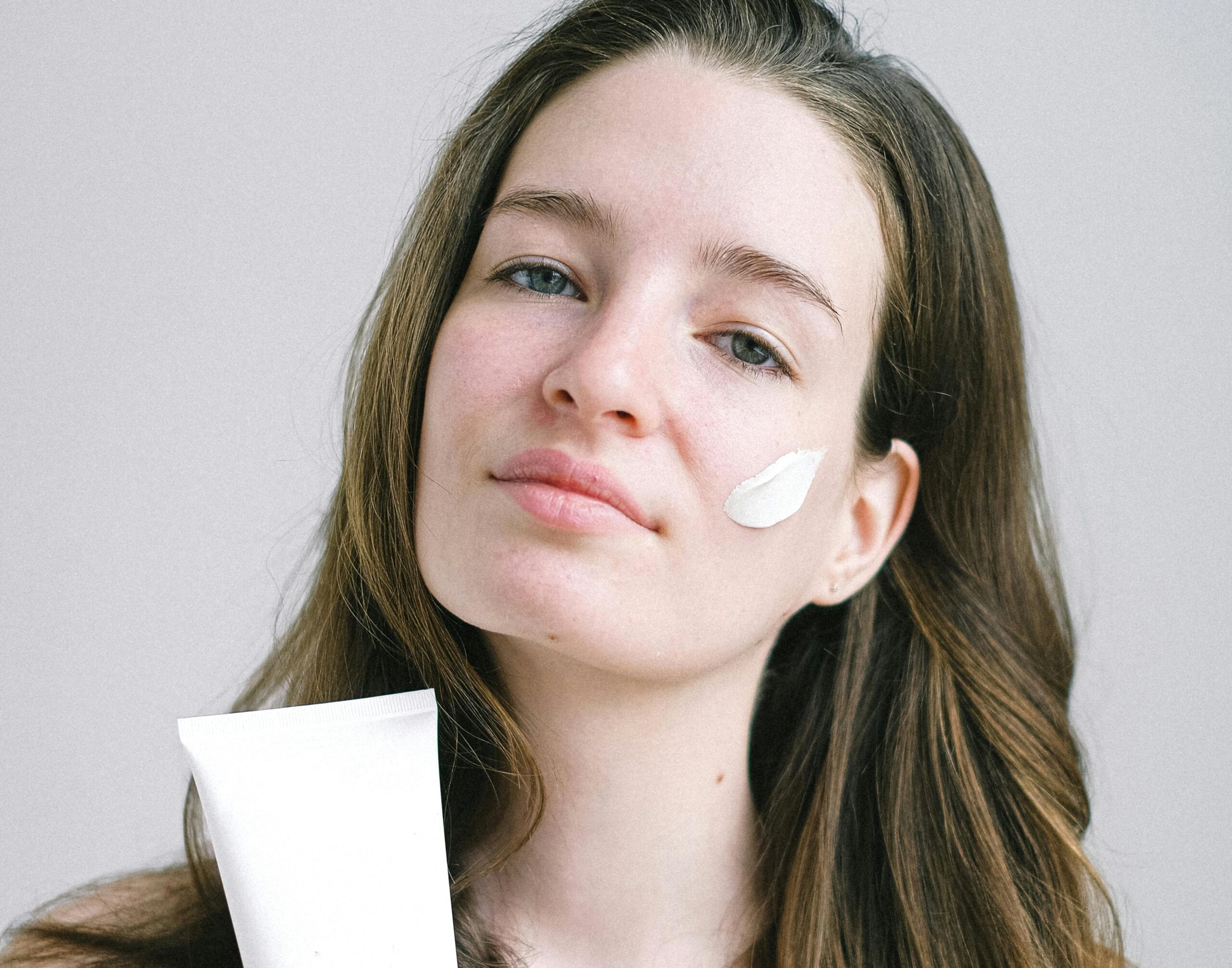 Dziewczyna trzymająca krem złuszczający do twarzy